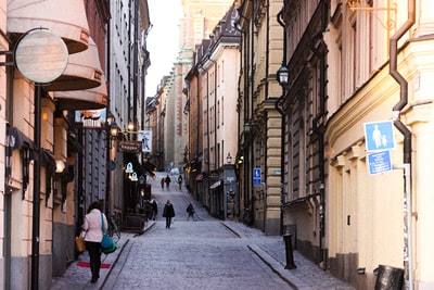 During the day, people walking in the streets of between buildings
